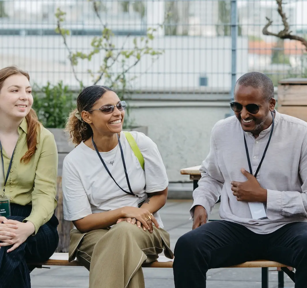 Drei Therapeut:innen lachen gemeinsam bei einem It's Complicated Community-Treffen
