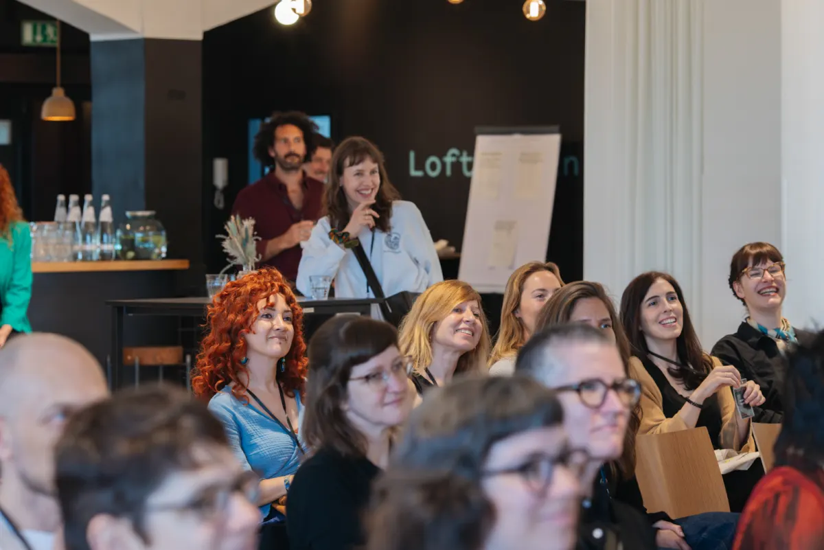Conference participants laughing together during a session