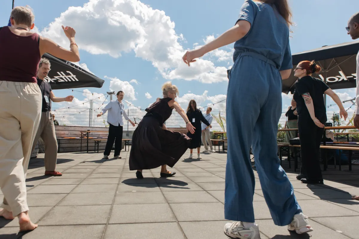 Participants moving together outside beneath a blue sky