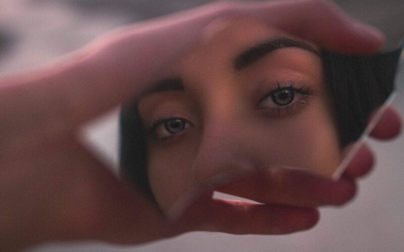 Shallow Focus Photo of Woman's Reflection on Broken Mirror