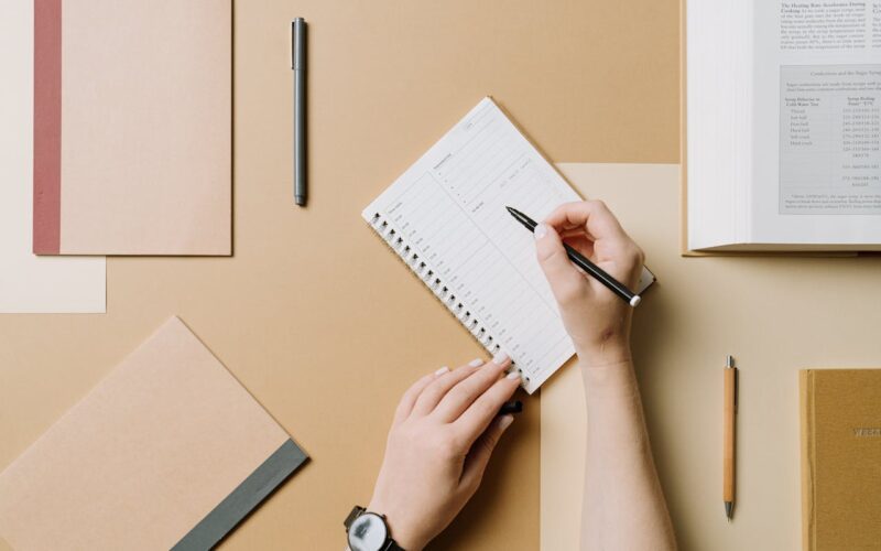 Top View of Woman Writing in a Planner