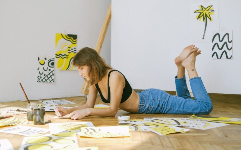 Photo of Woman Lying on Floor While Painting