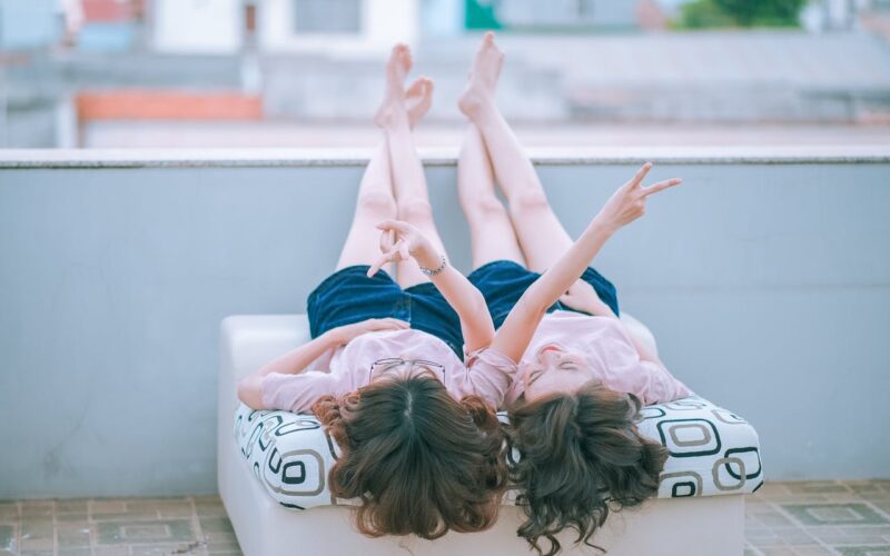Two women lying on a white mattress