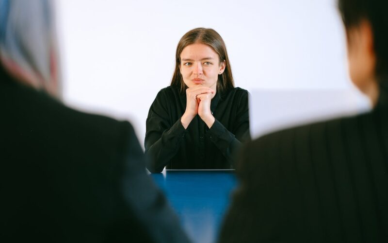 Woman in Black Blazer Sitting Being Interviewed