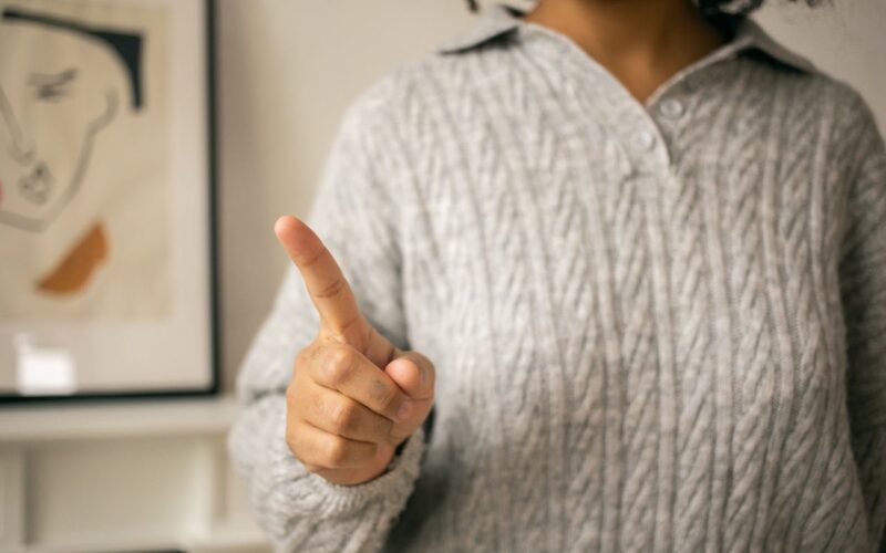 woman pointing finger in light room