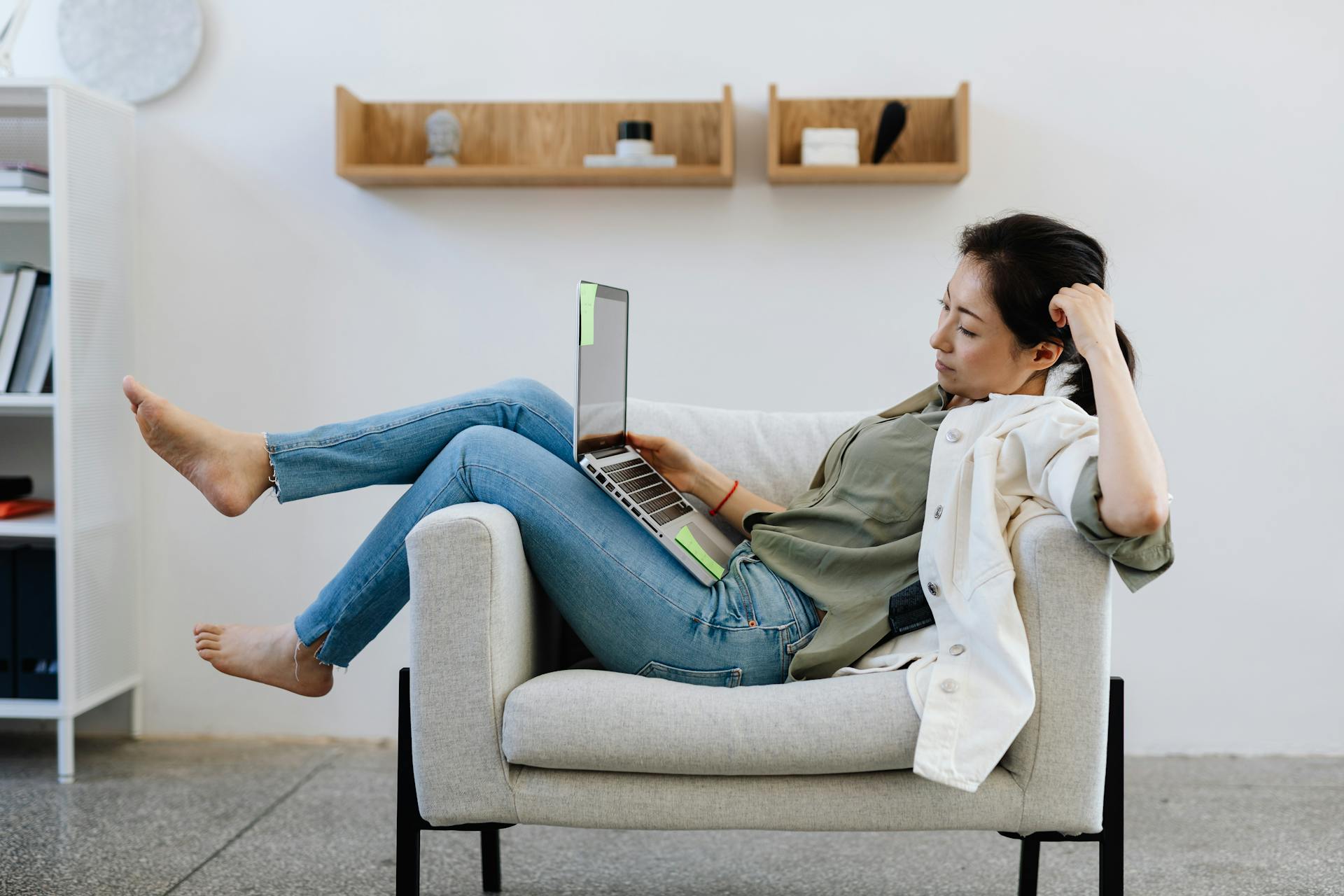 Woman sitting at laptop across a sofa