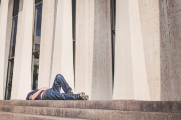 a man resting on building steps