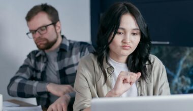 A Man and Woman Sitting at Laptop Frowning