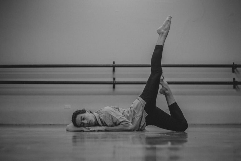 Man in dance studio posing against floor