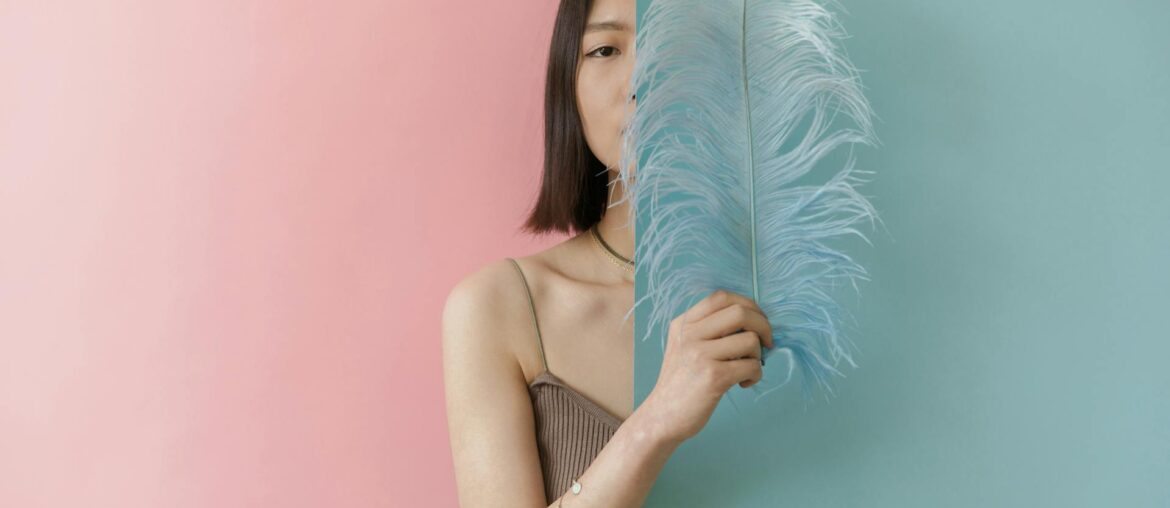 Woman in Brown Stripe Tube Top Holding Blue Feather