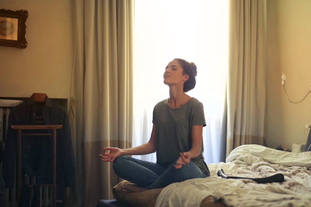 A woman meditating on the bed