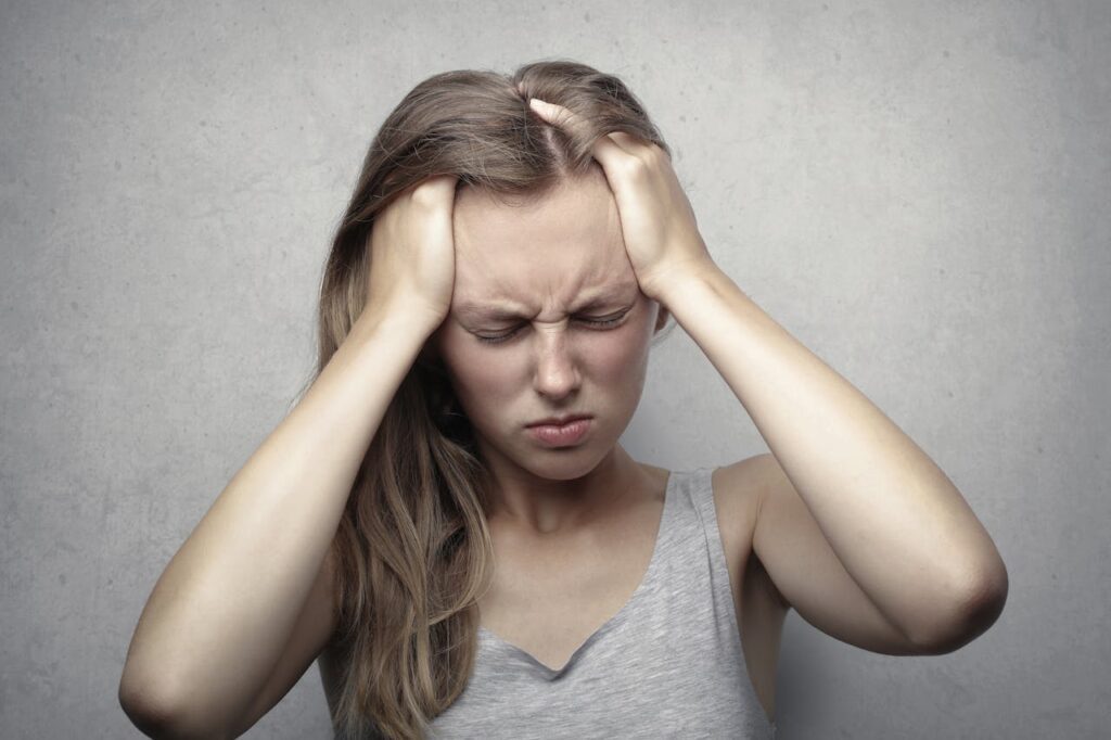 A displeased woman with her hands on her head