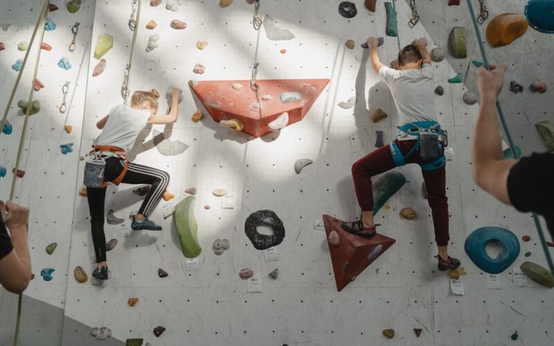 Young Man and Girl Climbing on A Rock Wall