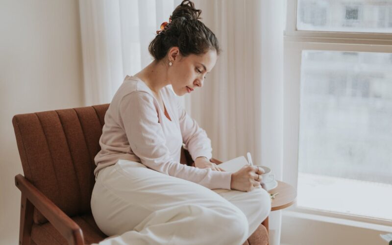 Woman Journaling by the Window in Natural Light