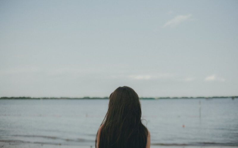 Woman Standing Near Body of Water during Daytime