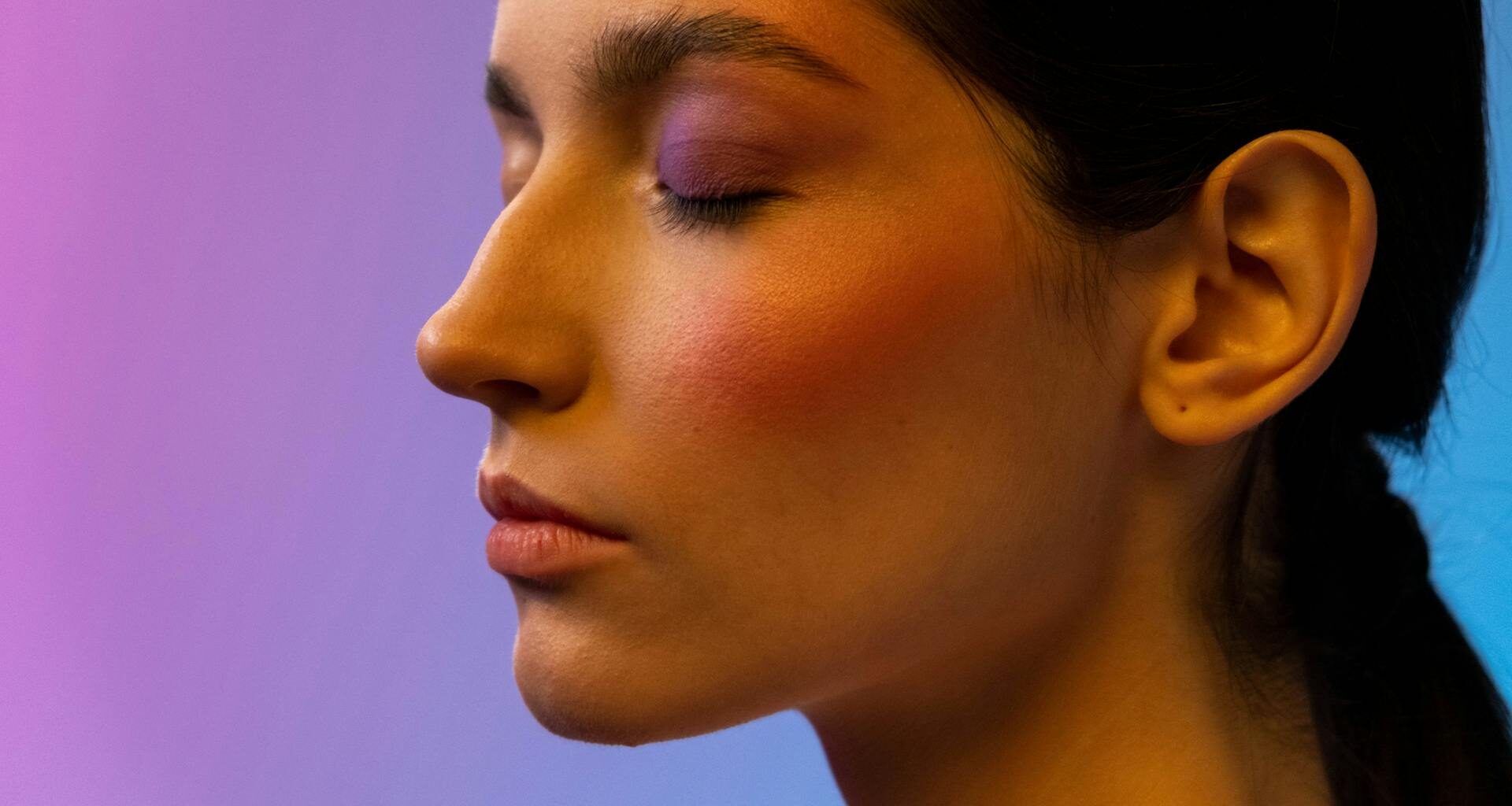 Deeply focused woman closing her eyes against a multicolour background