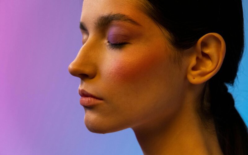 Deeply focused woman closing her eyes against a multicolour background