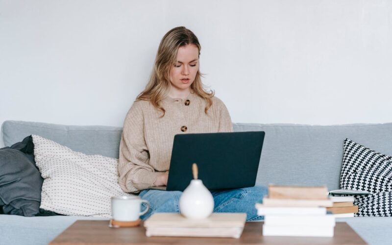 Serious woman searching for therapist with laptop at home