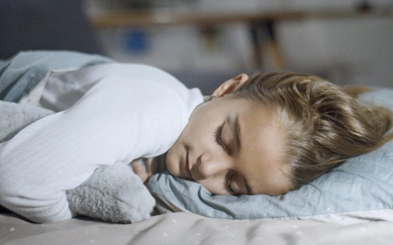 A Young Girl in White Long Sleeve Shirt Sleeping