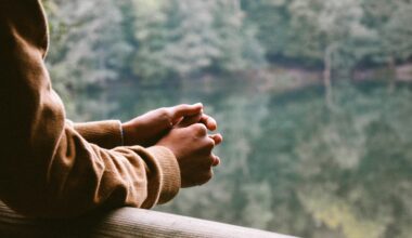 A woman contemplates while looking at a lake. Many expats experience mental health issues including depression.