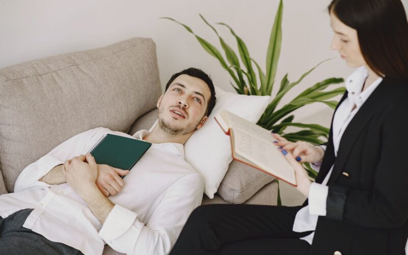 A focused therapist listens to a patient during a psychotherapy session
