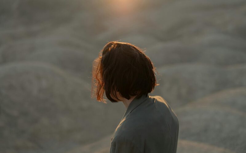 Contemplative moment captured in a desert landscape with a person in a suit at sunset