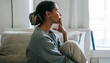 A troubled young woman sits in a relaxed pose in a serene bedroom, reflecting